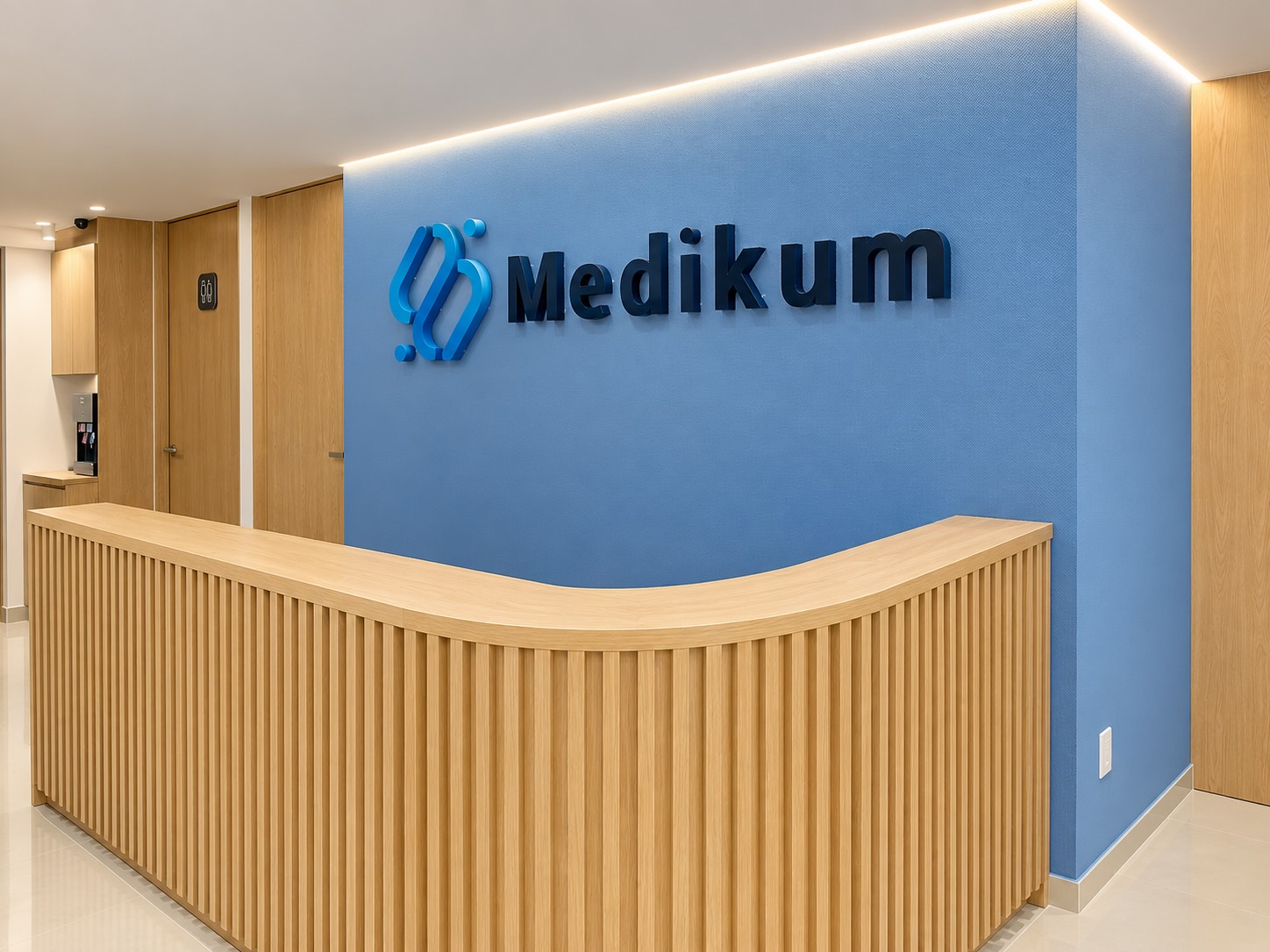 Recepción de Medikum con logotipo en muro azul